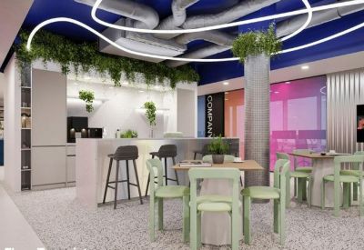 Communal kitchen and breakout area with a breakfast bar, green seating, and neon ceiling lights.