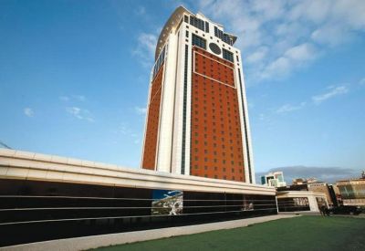 Exterior view of the modern, high-rise Flora Suite Office building against a blue sky.