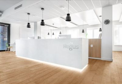 Bright white reception area with a minimalist front desk and hanging lamps.