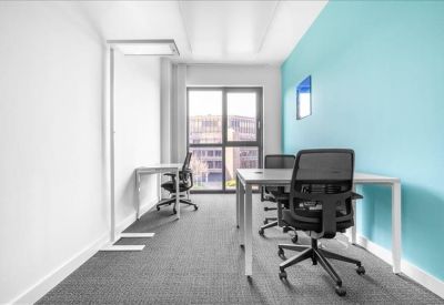 Bright corner office with a blue feature wall and black mesh chairs.