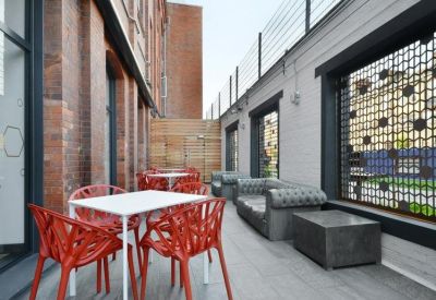 Outdoor terrace with red designer chairs and comfortable grey sofas.