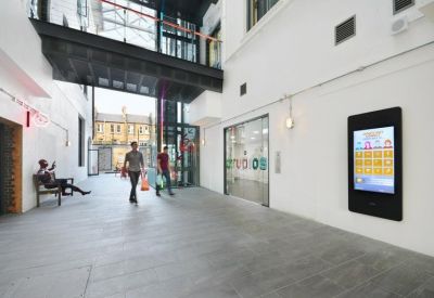Spacious modern lobby with digital directory and sky bridge overhead.