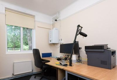 Professional workspace with dual monitor setup, printer, and large window.