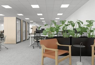 Lounge area with tan leather armchairs and lush green potted plants.