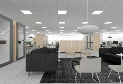 Modern breakout space with dark sofas and a circular pendant light.