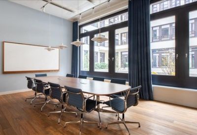 Vibrant breakout area with blue walls, yellow bar stools, and a yellow rug.