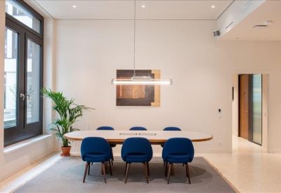 Bright reception desk with backlit bottom edge and wood-slat wall.