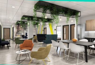 Bright communal lounge with colorful armchairs, dining area, and hanging plants.