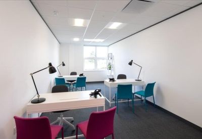 Private office suite with white desks, teal chairs, and black desk lamps.