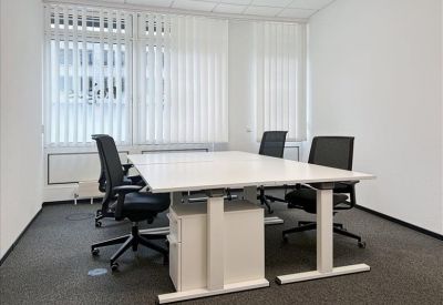 Private office with white desks and black mesh chairs.