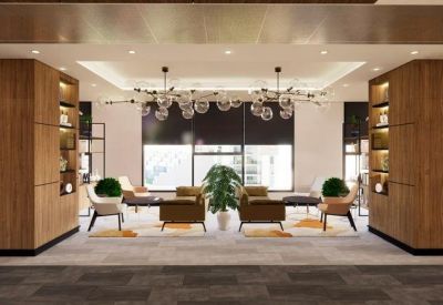 Lounge area with wood paneling, designer lighting, and plush armchairs.