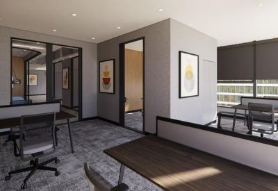 Modern open-plan office space with wood-topped desks and ergonomic chairs.