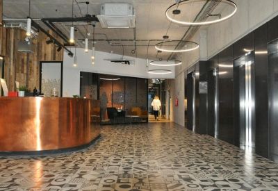 Sleek building lobby with a curved copper reception desk and decorative tiled flooring.