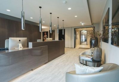 Modern reception area with glossy desk and minimalist pendant lighting.