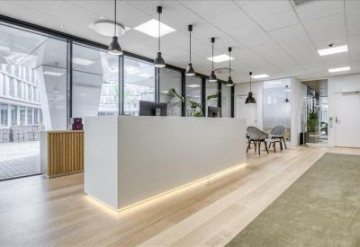 Sleek white reception desk with warm under-lighting and stylish pendant lamps.