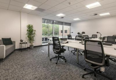 Open-plan office with numerous desks and chairs.
