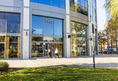 Modern building entrance with large glass doors and numerical signage.