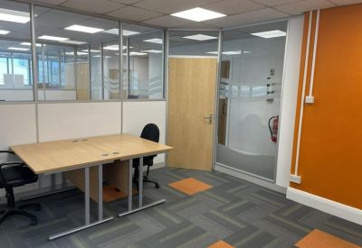 Office area with desk and orange feature wall.
