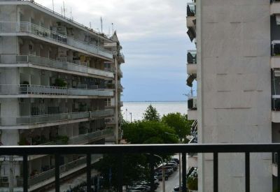 View from the office balcony overlooking city apartment buildings and a glimpse of the sea.