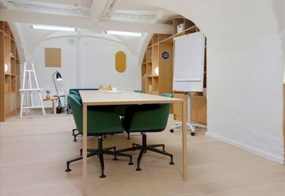 Workspace featuring green swivel chairs and light wood shelving units.