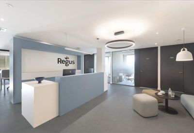Bright reception area with a blue and white desk and minimalist lounge seating.