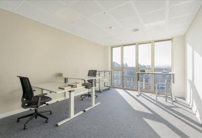 Spacious two-person office suite with sit-stand desks and large windows.