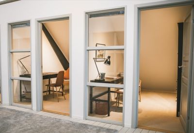 Private office pods with glass doors and individual desks.