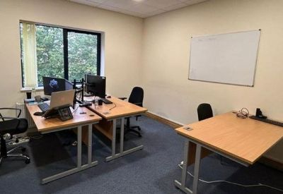 Three-person private office suite with wooden desks and a whiteboard.
