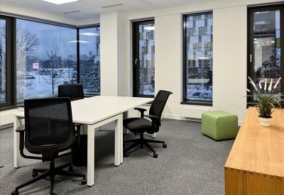 Private corner office with four desks and views through large windows.