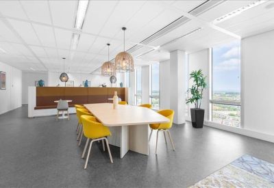 Modern communal dining area featuring yellow chairs and stylish wicker pendant lights.