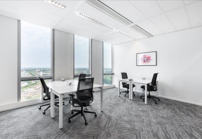 Bright corner office suite with white desks and floor-to-ceiling windows.