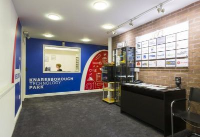 Professional reception area with a branded blue wall and visitor seating.