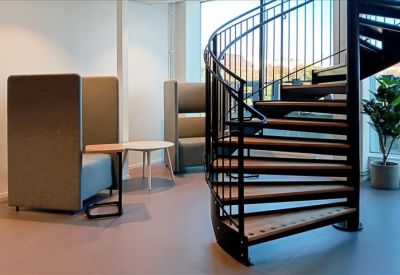 Reception area showing a black spiral staircase and cozy seating nooks.