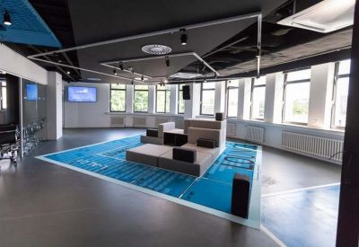 Spacious communal lounge with tiered seating on a blue geometric floor map.