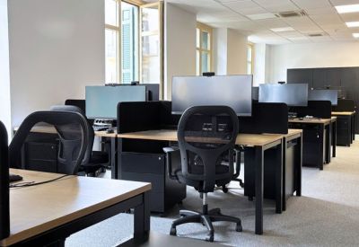 Outdoor terrace lounge area with blue armchairs and wooden flooring.