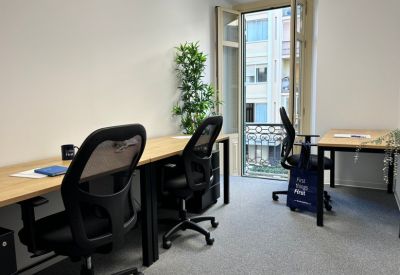 Light-filled private office with two desks and a balcony view.