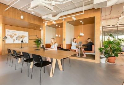 Spacious communal area with a long wooden table, built-in seating booths, and warm lighting.