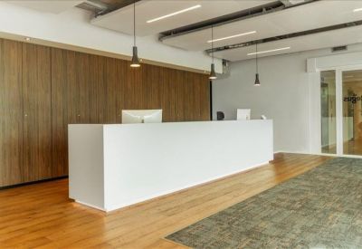 Minimalist white reception desk with warm wood flooring and timber wall paneling.