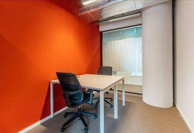 Small private office suite with an orange feature wall and two desks.