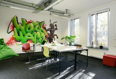 Creative office space with a large 'Work Hard' graffiti mural and industrial ceiling.