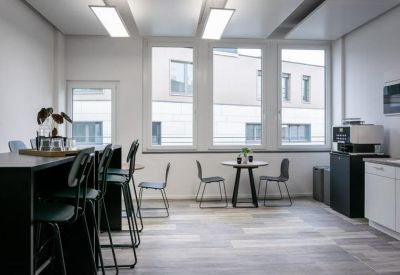 Communal kitchen and dining area with high bar stools and small cafe tables.