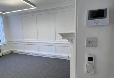 Private office space featuring classic wall paneling and a modern LED light fixture.