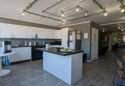 Bright communal kitchen and breakout area with a central island and decorative fairy lights.