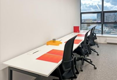 Shared workspace with white desks and black mesh chairs.