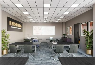 Classroom-style meeting room with dark desks and potted plants.