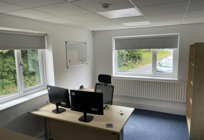 Private office suite with two computer monitors and natural light.