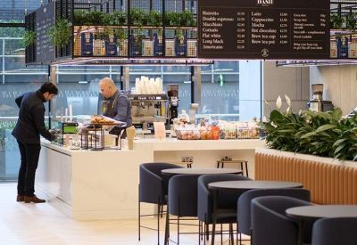 Modern on-site café with a black menu board and bar seating.