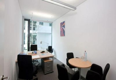 Private office suite with a wooden desk and a small circular meeting table.