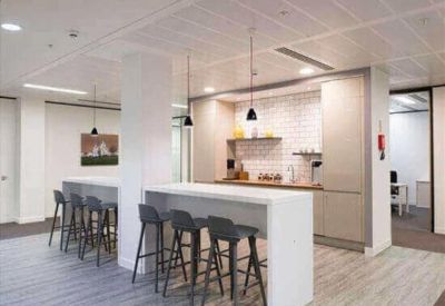 Communal kitchen area with two long white breakfast bars and stylish pendant lighting.