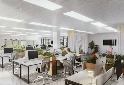Bright open-plan office with white desks, ergonomic chairs, and integrated planters.